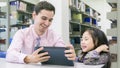 man teacher and kid student learning and looking on tablet device