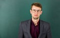 Man teacher wear eyeglasses for vision green chalkboard background, intelligent guy concept
