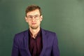 Man teacher wear eyeglasses for vision green chalkboard background, intelligent guy concept