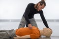 Man teaching cardiopulmonary resuscitation with a dummy on a white background. Pinching the injured to see if he responds to pain