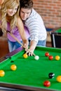 Man teaching his girlfriend how to play pool Royalty Free Stock Photo