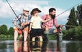 Man teaching kids how to fish in river. Grandfather, father and boy fishing together. Dad and son fishing at lake Royalty Free Stock Photo