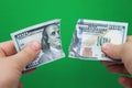 Man tearing dollars on green background