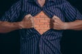 Man tears off his shirt, and under it is brick wall, symbolizing inner strength and steadfastness Royalty Free Stock Photo