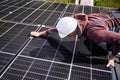 Man technician mounting photovoltaic solar panels on roof of house with help of hex key. Royalty Free Stock Photo