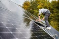 Man technician mounting photovoltaic solar panels on roof of house with help of hex key. Royalty Free Stock Photo