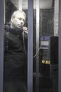 Man in a telephone booth at night