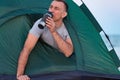 Man in tent drinks from tourist mug. Morning hike. Camping Royalty Free Stock Photo