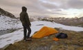 Man with tent observes the Alps