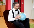 Man with terrestrial globe in his living room Royalty Free Stock Photo
