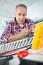 man testing electronics another noting results