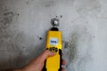 Man testing the humidity in a wall with a moisture meter.