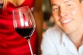 Man testing wine in background barrels