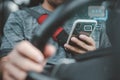 Man Texting while driving car. Irresponsible man Chatting and using smartphone. Writing and typing message with cellphone in vehic Royalty Free Stock Photo