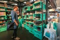 Man thinking about beer inside colorful design store by popular Mikkeller brewery with choice of bottles