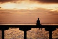 Man thinking on edge of pier at sunset Royalty Free Stock Photo