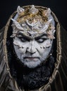 Man with thorns or warts, face covered with glitters. Demon with golden hood on black background. Senior man with white Royalty Free Stock Photo