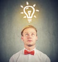 Man with thoughtful expression and bright light bulb over his head Royalty Free Stock Photo