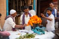 Man threading colourful flower garlands in Delhi