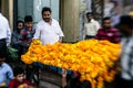 Man threading colourful flower garlands in Delhi