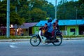 A man with three children rides a motorbike. Motorbike in Asia