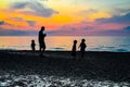 Man and three children silhouetted at sunset on the shoreline of Lake Michigan near the Indiana Dunes State Park Royalty Free Stock Photo