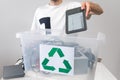 Man throwing away broken electronic book in recycle container.