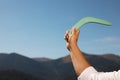 Man throwing boomerang in mountains, closeup. Space for text