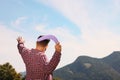 Man throwing boomerang in mountains on sunny day, back view. Space for text