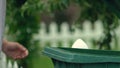 Man throwing garbage bag in green plastic container, waste utilization, ecology