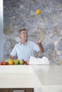 Man Throwing Orange Into Air At Kitchen Counter Royalty Free Stock Photo