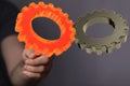 Man throwing orange and gray gears - 3D renderred cogwheels