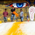 Man throwing orange paint on Boudhanath stupa Royalty Free Stock Photo
