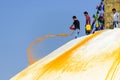 Man throwing orange paint on Boudhanath stupa Royalty Free Stock Photo