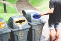 Man throwing plastic bottle in recycle trash can