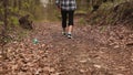 A man throws a bottle in the woods