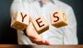 A man throws cubes with letters and makes up the word YES. Agreement and acceptance, answer the question. Courage Royalty Free Stock Photo