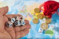 A man throws dice with red and blue markings on the world map. World order, map and money. Royalty Free Stock Photo