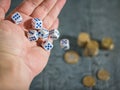 The man throws the game dice on the table with coins. Money and game cubes. Royalty Free Stock Photo