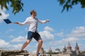 Man throws notebook against blue sky