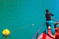 A man throws a rope to tie up the Tour boat with buoys. Royalty Free Stock Photo