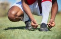 Man tie football shoes lace on soccer field, athlete ready for sports training in Portugal and exercise on grass stadium Royalty Free Stock Photo