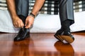 Man ties his shiney new black leather business shoes.