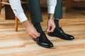 Man ties his shiney new black leather shoes