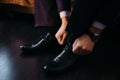 Man ties the laces on his polished shoes. Business formal dress style