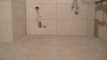 Laying tiles in the bathroom. Man tiling a wall in the bathroom. Ceramic Tiles. Tiler placing ceramic wall tile in position over Royalty Free Stock Photo