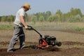 A man tilling ground with motor-cultivator