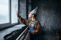 Man in tinfoil cap looking out the window, UFO Royalty Free Stock Photo