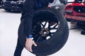 Man tire change service holding car wheel. Royalty Free Stock Photo