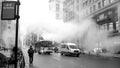 Man to walk on the road 5ÃÂ° avenue New York with cars to circular and smoke and water vapor to get off the ground.